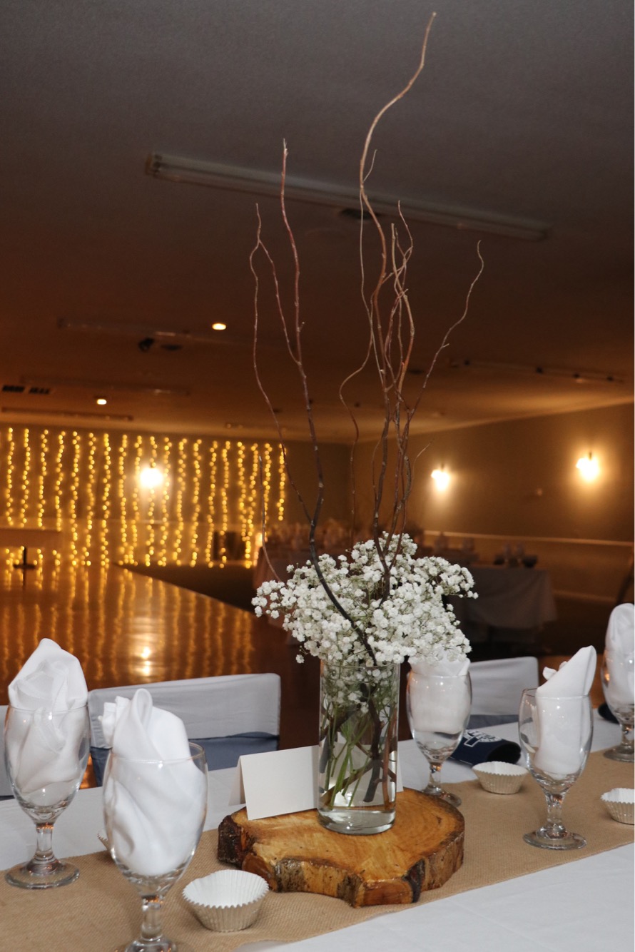 Table Wedding Reception Decorations including flowers and table decorations with lights handing from the walls